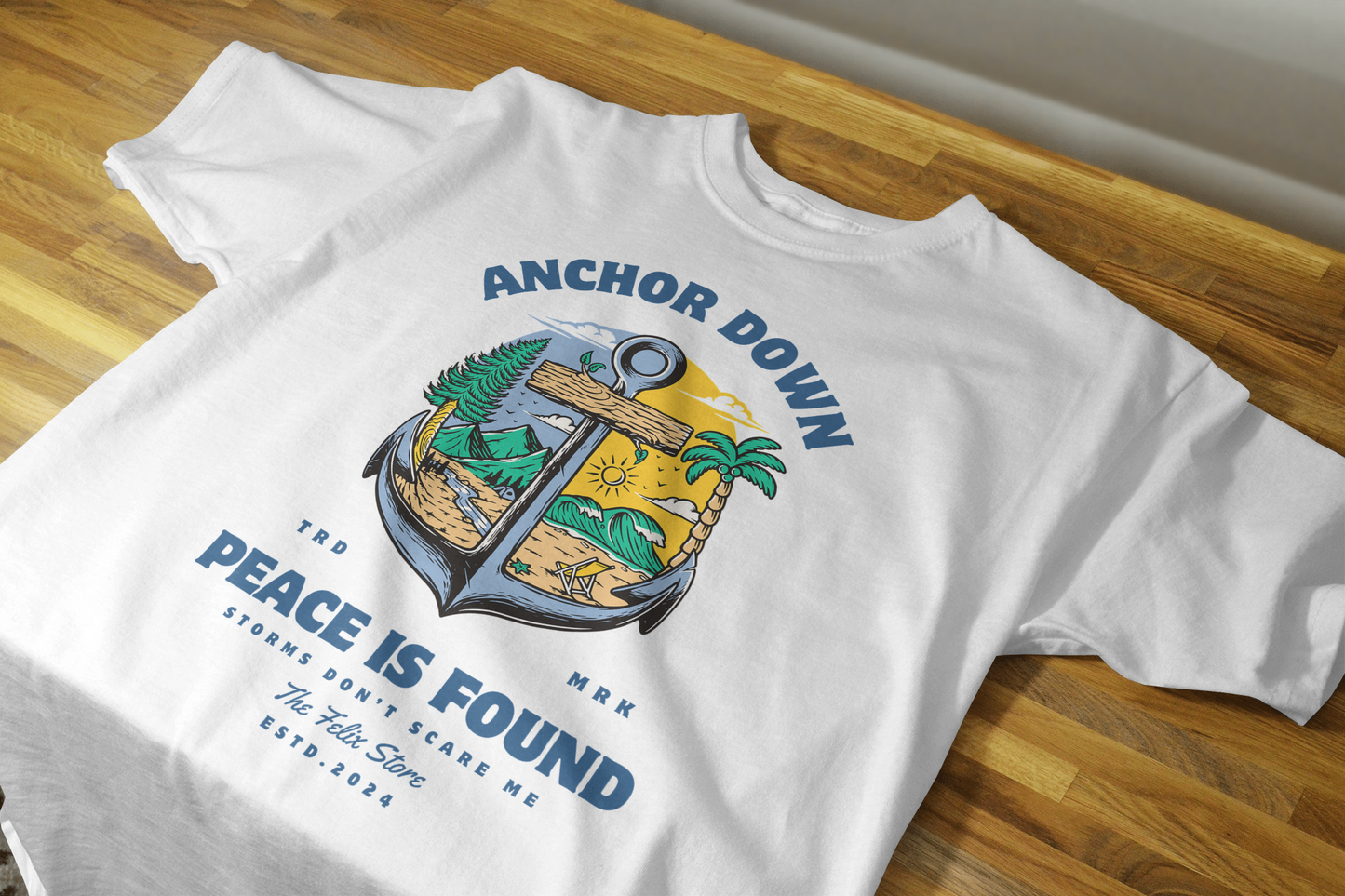 "Anchor Down Peace is Found graphic t-shirt by The Felix Store featuring anchor, palm trees, mountains, and sunshine in artistic beach-forest design"