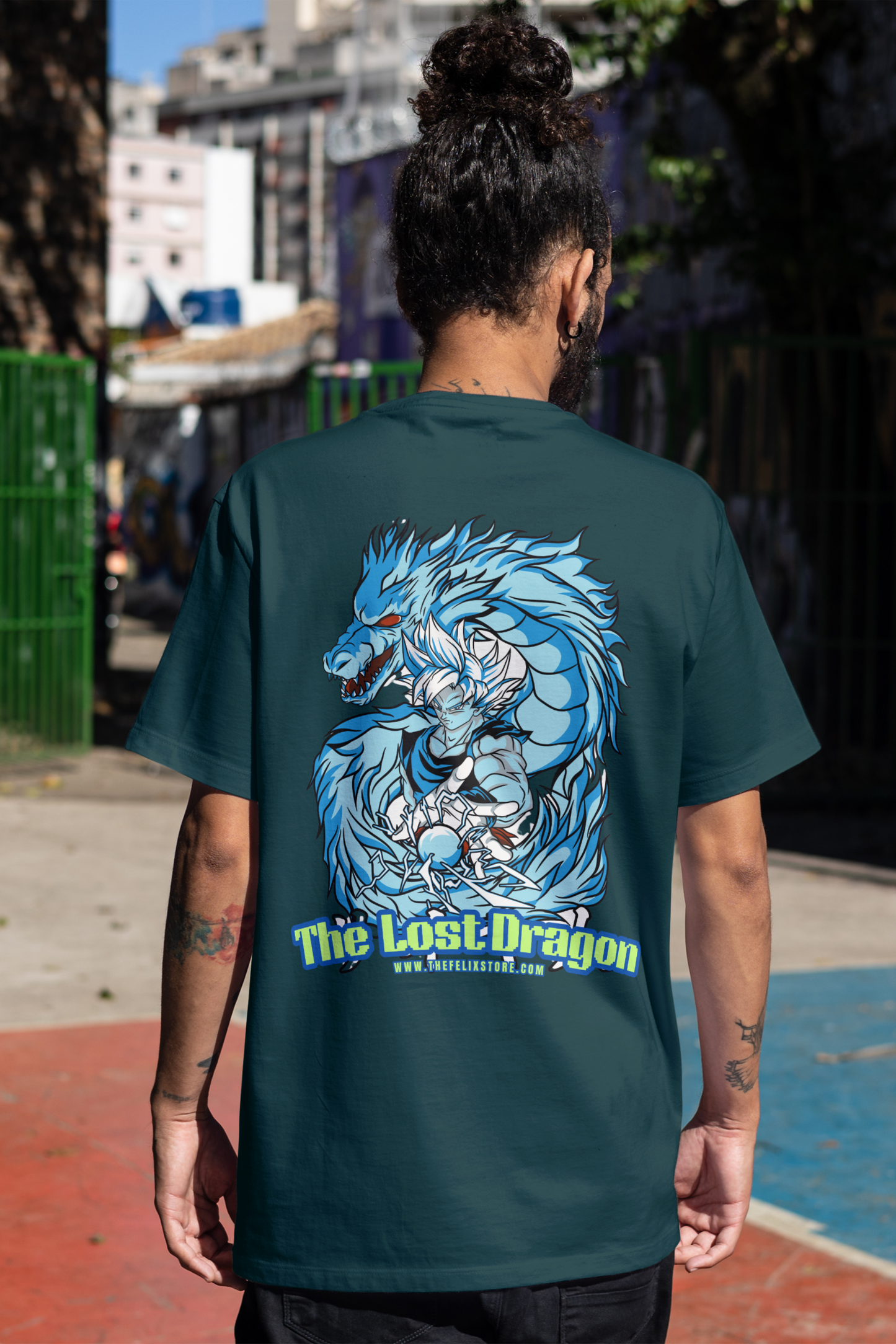 Person wearing a teal t-shirt with 'The Lost Dragon' graphic design on the back, standing outdoors.