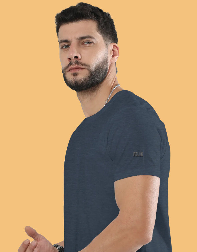 Man wearing a premium crew neck T-shirt with subtle FELIX logo on the sleeve, part of The Felix Store's 9-color plain and melange collection.