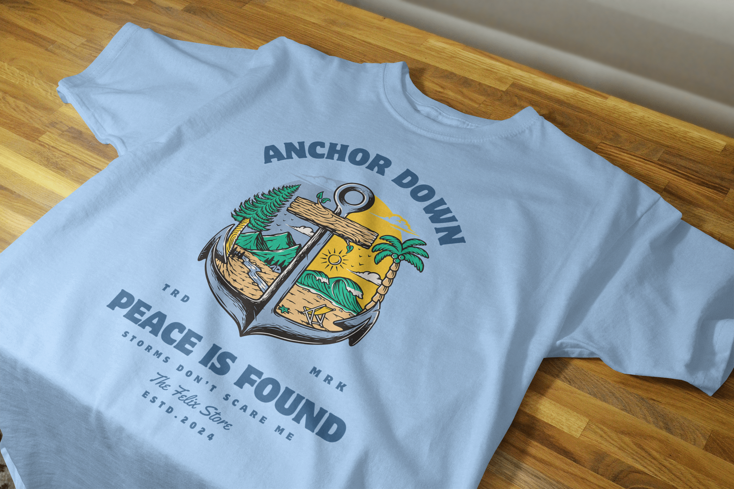 "Anchor Down Peace is Found graphic t-shirt by The Felix Store featuring anchor, palm trees, mountains, and sunshine in artistic beach-forest design"
