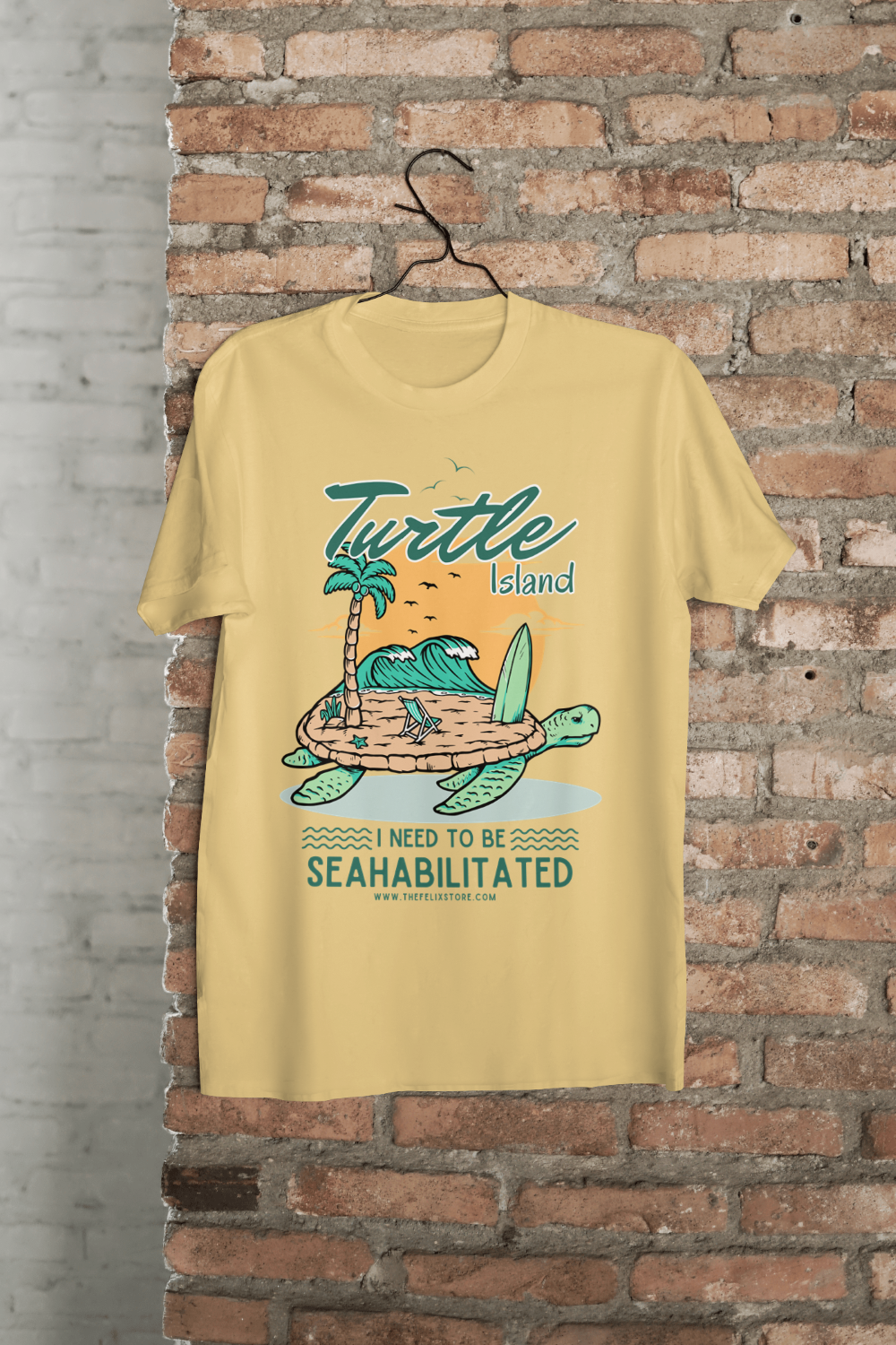 t-shirt featuring a colorful turtle carrying a tropical island with the phrase “I Need to Be Seahabilitated” 