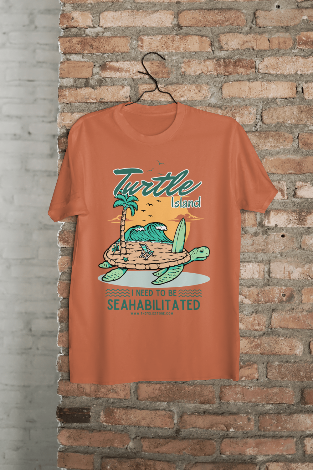 t-shirt featuring a colorful turtle carrying a tropical island with the phrase “I Need to Be Seahabilitated” 