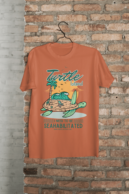 t-shirt featuring a colorful turtle carrying a tropical island with the phrase “I Need to Be Seahabilitated” 